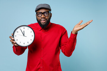 Perplexed worried young bearded african american man 20s in casual red shirt eyeglasses cap...
