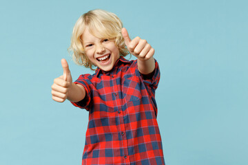 Funny little curly kid boy 10s years old in basic red checkered shirt showing thumbs up like...