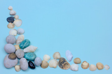 seashells, white, blue and black stones on a blue background. amazonite and sea pebbles