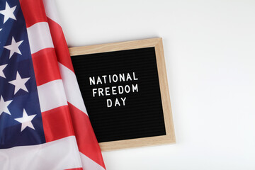 black letter board with text national freedom day and American flag on white background . top view flat lay copy space 
