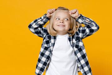 Little cute fun happy blond long-haired kid boy 5 years old wearing casual clothes posing isolated on bright yellow wall color background children studio portrait. People childhood lifestyle concept