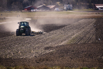 Tractor farmer plowing field ploughing soil farming dust agriculture