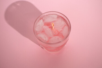 Pink drink with ice cubes. Drowning hand. Drunk in love. Valentine's day aesthetic.