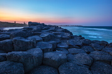 Colourful sunrise over Fingal Causeway . An amazing formation of basalt rock columns at Fingal Head...