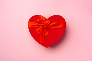 Heart shaped red gift box on pink background