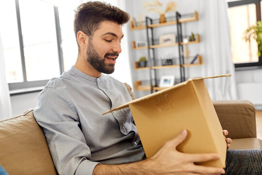 Mail Delivery, Shipment And People Concept - Happy Smiling Man With Open Parcel Box At Home