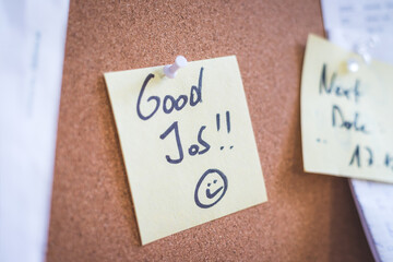 Employee motivation and leadership concept. “Good Job” note on pinned paper, cork board