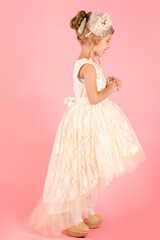 little princess in white dress isolated on pink background