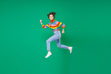 Fototapeta na wymiar Full length side view of smiling laughing funny young brunette woman 20s years old wearing basic casual colorful sweater jumping like running isolated on bright green color background studio portrait.