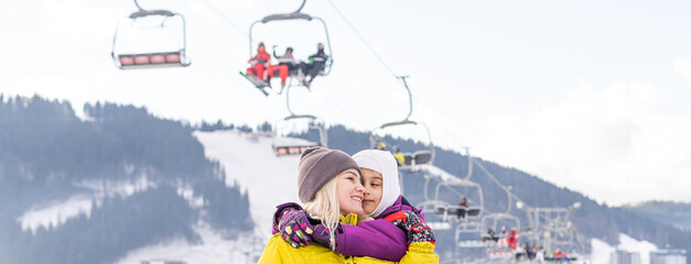 mother and daughter with snowboards at winter resort