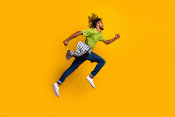 Fototapeta na wymiar Photo portrait full body side view of man running jumping up isolated on vivid yellow colored background