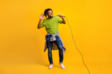 Photo portrait full body view of man holding microphone singing isolated on vivid yellow colored...