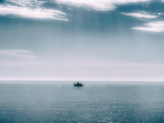 Barco de pesca en un mar en calma con nubes