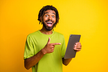 Photo of young handsome man excited happy smile show point finger tablet advert promotion advice...