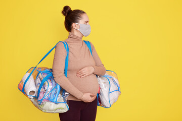 Bags of baby clothes, stuff, pregnant woman being ready for going to maternity hospital, lady...