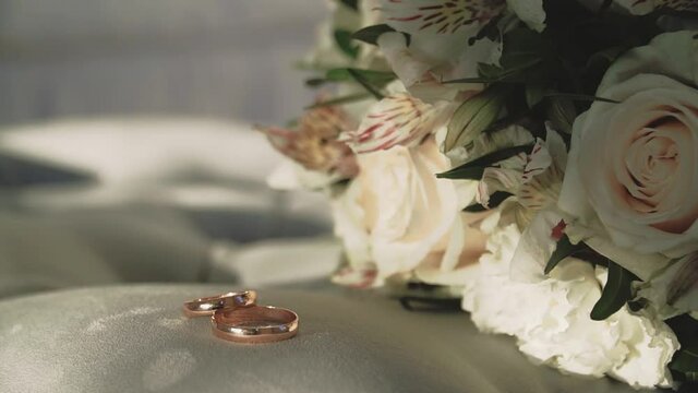 Beautiful bouquet of flowers and gold wedding rings