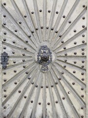 Old exterior door made of solid wood with sunshine decor and metal rivets. Alte Aussentür aus Massivholz mit Sonnenstrahlen dekor und Metallnieten.