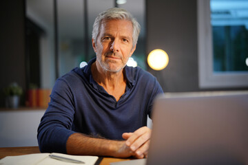 Obraz premium Portrait of senior man with grey hair connected with laptop