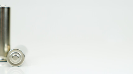 AA alkaline rechargeable batteries on white glossy background with reflection. Close up two empty...
