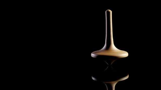 Close up shot of a wooden spinning top moving.