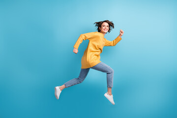 Fototapeta na wymiar Full length body side profile photo of female runner smiling cherfully jumping high isolated on vivid blue color background