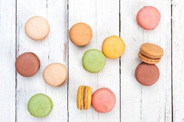 Colorful French macarons pastry on rustic table flat lay top view