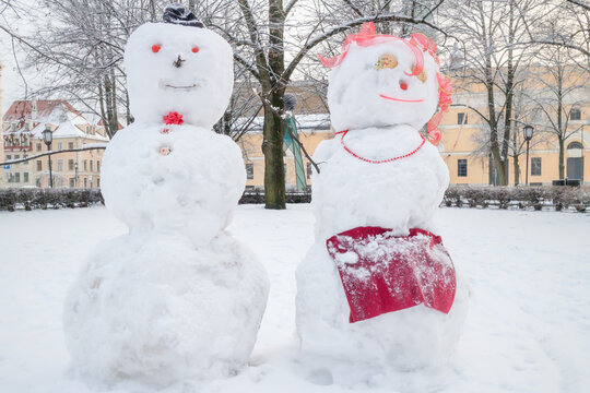 two funny snow figures - a snowman and a woman on a winter snowy day after a snowfall