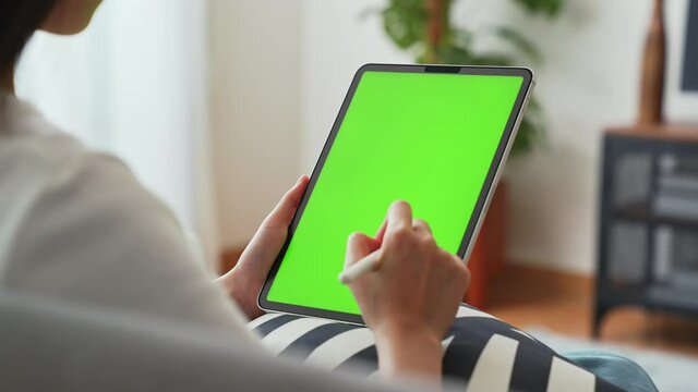 Close up of woman holding in hands a digital tablet with green screen for internet online, chromakey screen for advertising.
