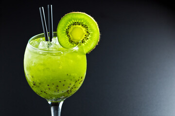 Green non-alcoholic cocktail. Cocktail with kiwi in a beautiful glass on a dark background.