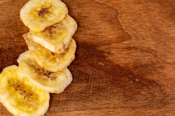 Dried banana slices on a wooden board