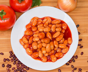 Beans stewed with tomato sauce on a dish, top view