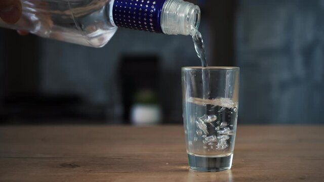 man pours vodka into a glass
