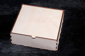 Rectangular wooden box with closed lid on a black surface
