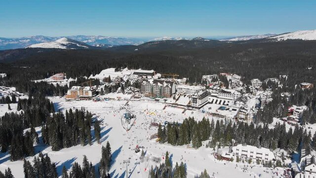 Aerial: Kopaonik Mountain ski resort center in Serbia, covered in snow, Pancic peak, Pancicev vrh, Raska, Sunny day in winter