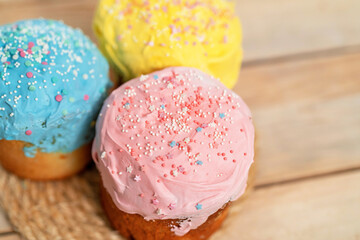 Sweet Easter cakes with colorful eggs on the table in the room.