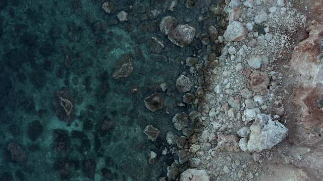 Beach in Malta - Drone footage of the maltese coast - Flying above a beach with rocks and clear water