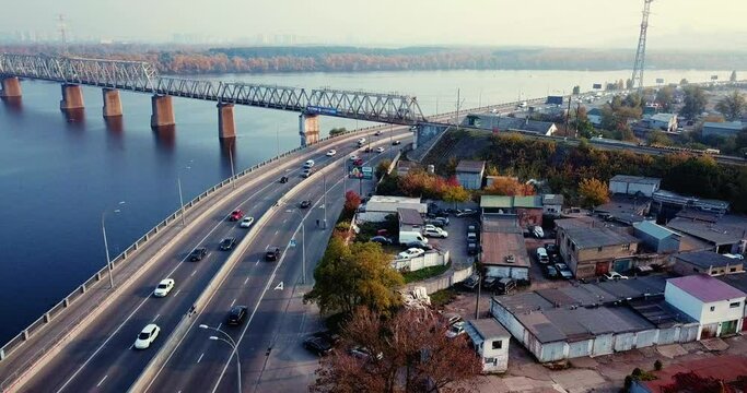 Flight over the highway, along the river and the industrial zone on the other side against the background of a railway bridge autumn, Kiev Ukraine.