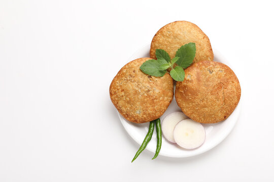 Kachori, green chilly and onion on white background. kachori is a spicy snack from India also spelled as kachauri and kachodi.