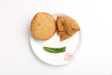 Kachori and potato samosa with green chilly in plate. famous spicy snack in india