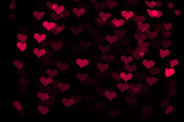Fototapeta na wymiar Pink hearts bokeh on black background