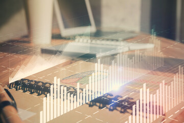 Obraz premium Double exposure of financial graph drawings and desk with open notebook background. Concept of forex market
