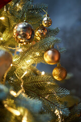 Winter Christmas background: green Christmas tree decorated with sparkling balls and cones, yellow garland lights