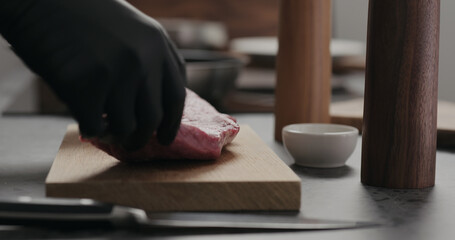 Fototapeta na wymiar man put raw beef steak on oak board