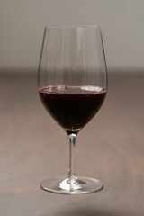 Red wine in thin wine glass on wood table