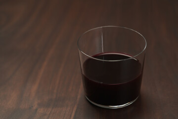 Red wine in thin tumbler glass on wood table