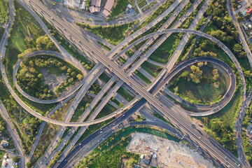 Aerial view of road interchange or highway intersection with busy urban traffic speeding on the...