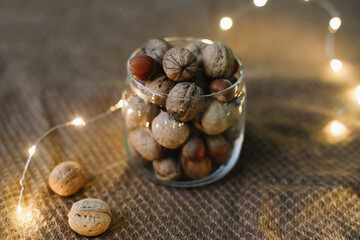 Mix of nuts in a jar on dark background. Walnuts and pine nuts. Top view. Copy space. Superfood,...