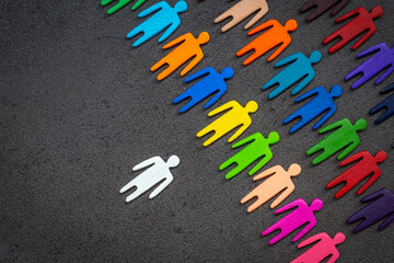 Equality and diversity concept. Multi-colored wooden figurines on a blackboard.