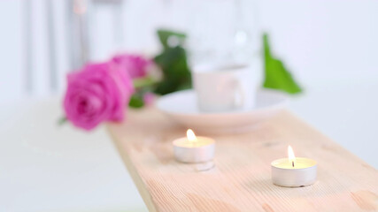 Fototapeta na wymiar Beautiful spa setting with pink candle and flowers on wooden background. Concept of spa treatment in salon. Atmosphere of relax, serenity and pleasure. Luxury lifestyle.