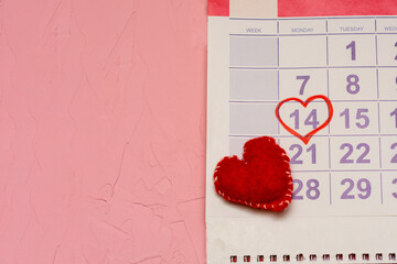 Wall calendar marked with date 14 February in shape of heart, reminder of Valentine's Day. Pink textured background for your text, copy space
